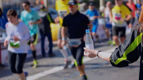 Helfer bei Marathon mit einer Wasserflasche